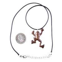 A brown frog pendant on a black cord necklace with silver lobster clasp. The frog is in a jumping pose with its legs outstretched.