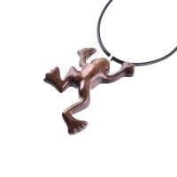 A brown frog pendant on a black cord necklace. The frog is in a jumping pose with its legs outstretched.