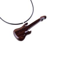 A wooden guitar pendant necklace with a black cord. The guitar is dark reddish- brown with a wood grain pattern.
