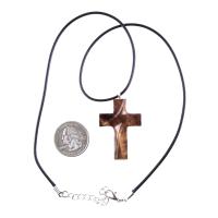A wooden cross pendant necklace carved in brown wood with black cord with silver lobster clasp. The pendant is intricately detailed and shows the wood grain. This handcrafted necklace is a unique and stylish accessory.