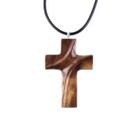 A wooden cross pendant necklace carved in brown wood with black cord. The pendant is intricately detailed and shows the wood grain. This handcrafted necklace is a unique and stylish accessory.