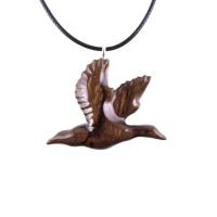 A dark brown wooden duck pendant on a black cord necklace. The bird is carved in flight with its wings spread out.