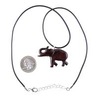 A dark brown wooden elephant pendant necklace with a black cord with silver lobster clasp next to a US quarter for scale.
