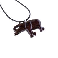 A dark brown wooden elephant pendant on a black cord necklace. The elephant is carved in a detailed, realistic style with a raised trunk and visible texture.