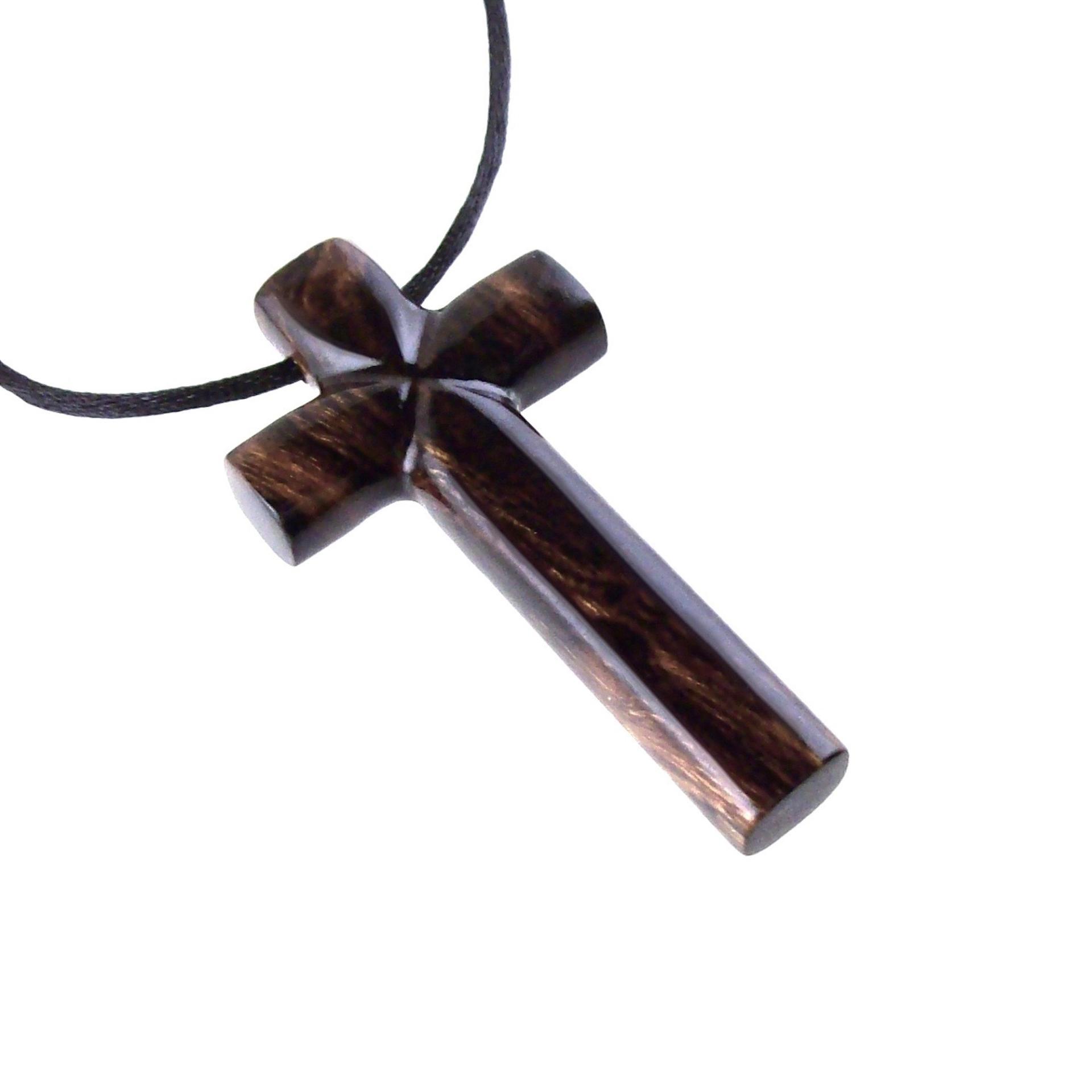 A dark brown wooden cross pendant on a black cord. It has a glossy smooth finish showing the wood grain.