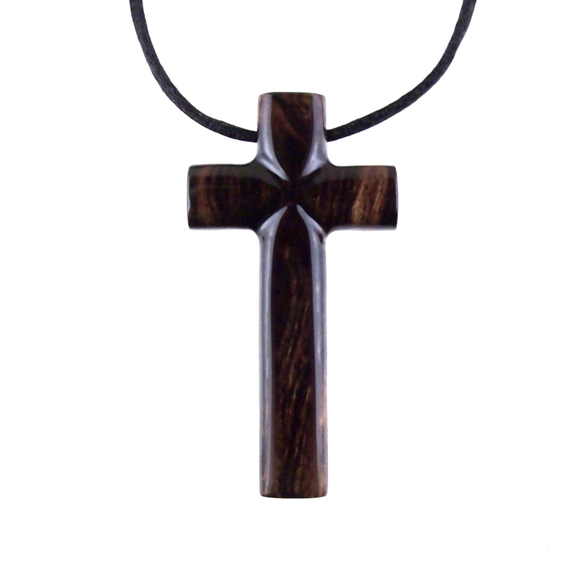 A dark brown wooden cross pendant hanging on a black cord. It has a glossy smooth finish with intricate wood grain.