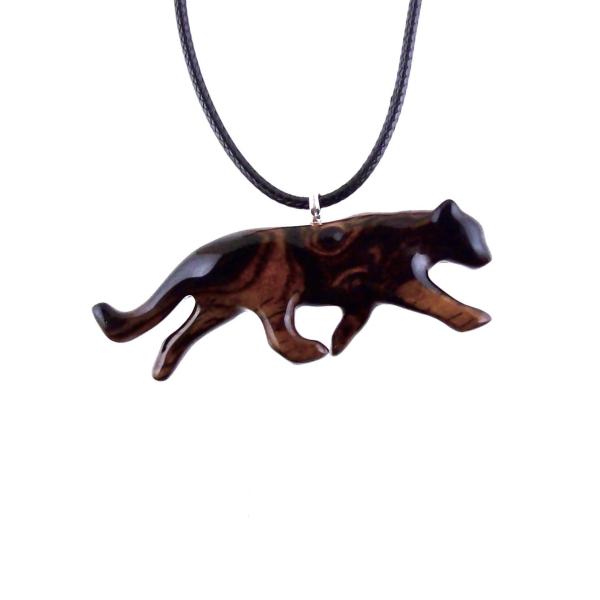 A dark reddish-brown wooden panther pendant necklace. The panther is carved in a leaping pose and hangs from a black cord. The pendant is intricately detailed and shows the wood grain. This handcrafted necklace is a unique and stylish accessory.